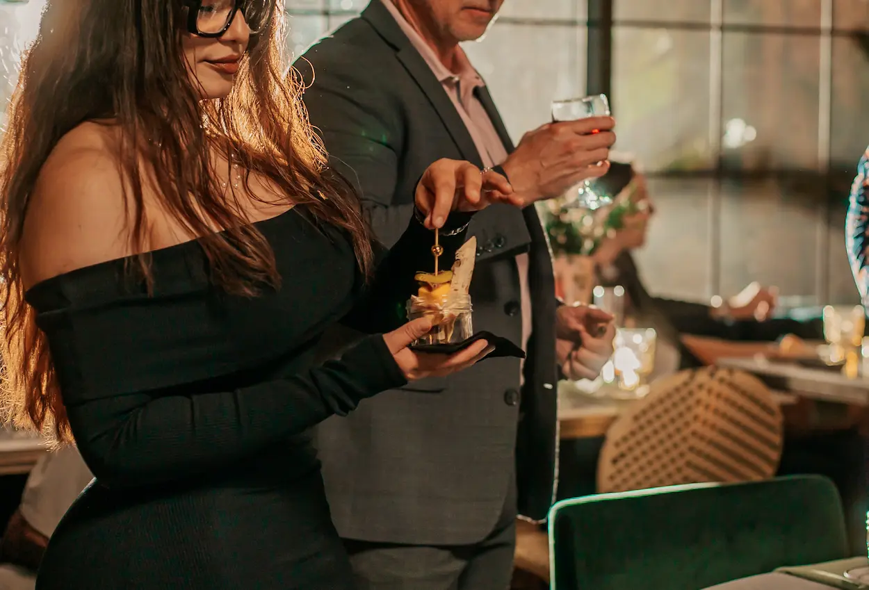 Professional chef plating gourmet dishes for guests at a luxury catered event in SoCal.